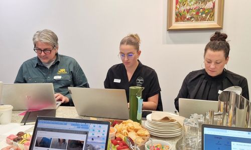 Workshop attendees optimising their Google Business Profiles with catering on the table with She Rocks Digital